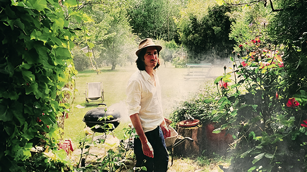 Portrait de Thomas Vassort dans un jardin verdoyant